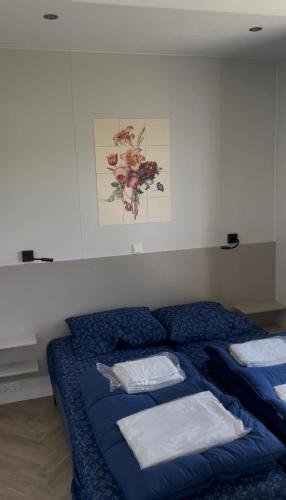 a bedroom with a blue bed with towels on it at Waddenlodge Premium in Harlingen