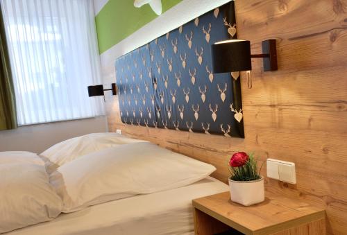 a bedroom with a bed and a table with a flower on it at Landhaus Elbert in Rheinböllen