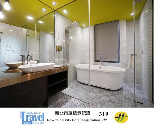 a bathroom with two sinks and a bath tub at Thinker Hotel in Yingge