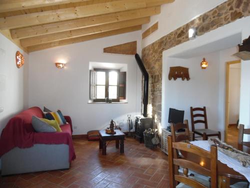 a living room with a red couch and a table at Quinta das Beldroegas-Turismo Rural in São Teotónio