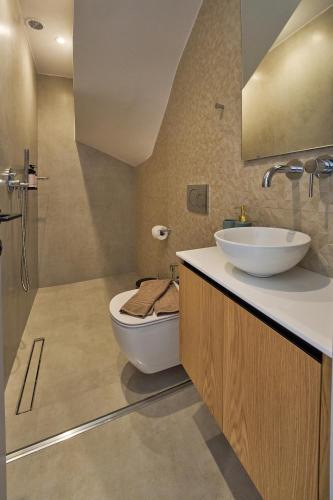 a bathroom with a white toilet and a sink at Bella Terra Natura in Roda