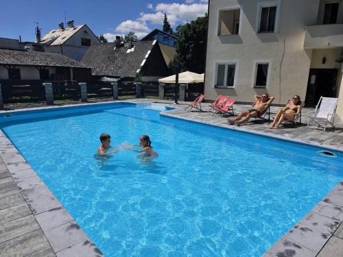 two children are playing in a swimming pool at Hotel Bellevue in Doksy