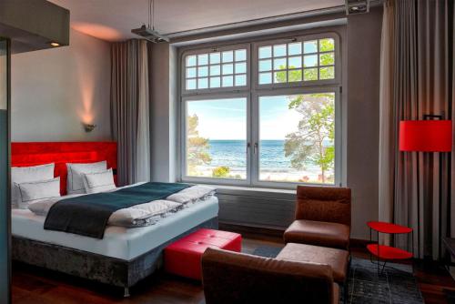 a bedroom with a bed and a large window at niXe Boutiquehotel & Spa in Binz