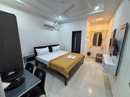 a bedroom with a bed and a table and a television at Hotel 7 dreamers in Vākalapūdi