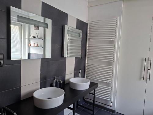 a bathroom with two sinks and a mirror at Pension Villa Maria in Karlovy Vary