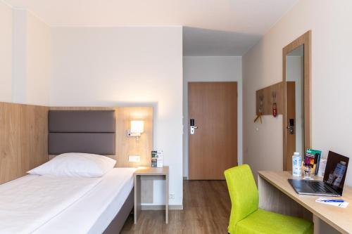 a bedroom with a bed and a desk and a chair at City-Hotel Kurfürst Balduin in Koblenz