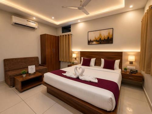 a bedroom with a bed with two towels on it at Accuotel Hotel Perfect in Indore