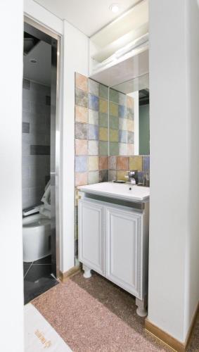 a bathroom with a sink and a toilet and a mirror at Eins Hotel in Seogwipo