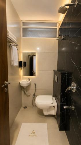 a bathroom with a toilet and a sink at Accuotel Hotel Perfect in Indore