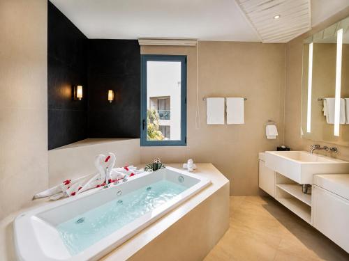 a bathroom with a tub and a sink at Teetara Villa Patong in Patong Beach