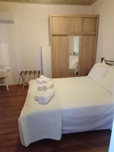 a bedroom with a white bed with towels on it at George's house samos in Pagóndas