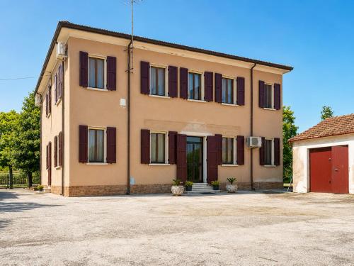 a building with red doors and a red garage at Ca'Mia - Rooms in Porto Tolle