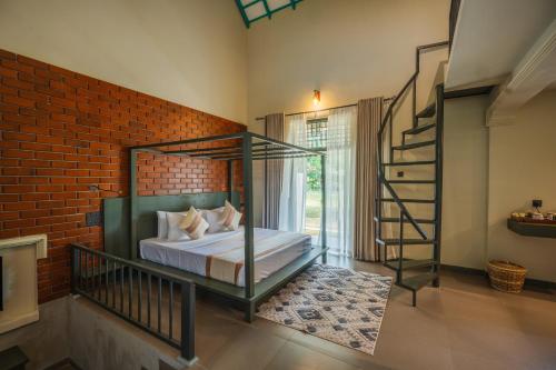 a bedroom with a bed and a brick wall at Cape Sigiriya in Sigiriya