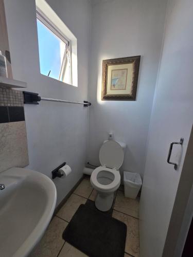 a bathroom with a toilet and a sink and a window at Deck Room with Neighborhood view in Bunkers Hill