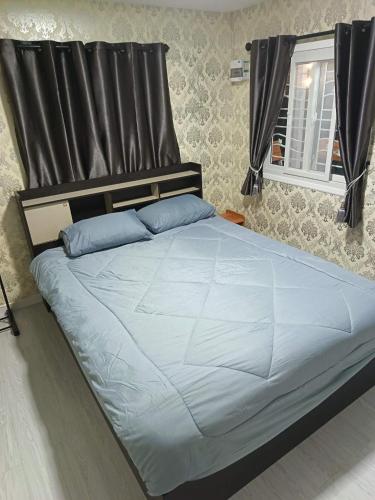 a large bed with blue pillows in a bedroom at Breeze Homestay in Nong Khai