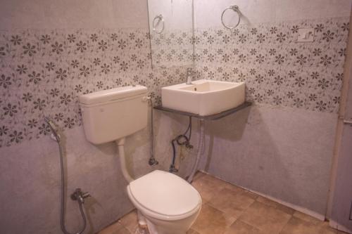 a bathroom with a toilet and a sink at Hotel Bluemoon in Guwahati