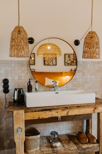 a bathroom with a sink and a mirror at Les Ecuries du bout du monde in Landunvez