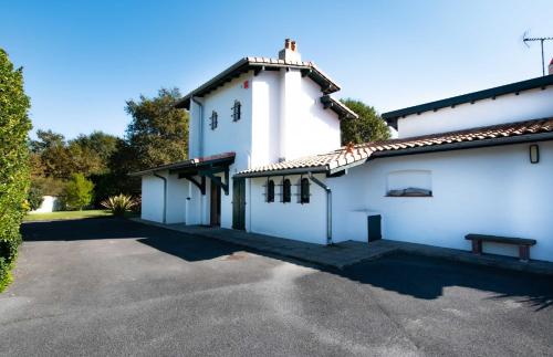 a white building with a parking lot in front at Villa des Landes - Seignosse - Jacuzzi in Seignosse