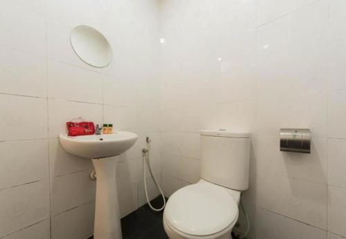 a white bathroom with a toilet and a sink at Cahaya Midah Hotel (BilikXpert) in Kuala Lumpur