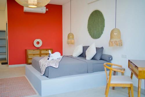 a bedroom with a blue bed and a red wall at Villa Mercure. Private villa. 2 en-suite bedrooms. in Amed