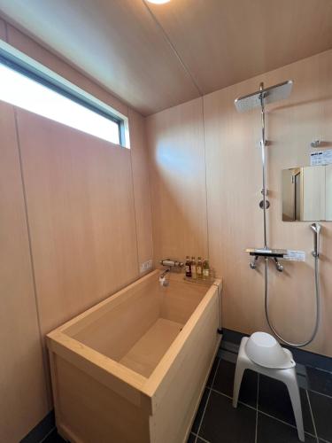 a bathroom with a large tub and a toilet at Hotel Cradle Cabin Tateyama in Tateyama