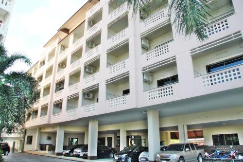 a white building with cars parked in front of it at Mana Residence in Hat Yai