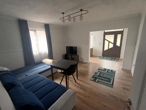 a living room with a blue couch and a table at Matei tiny house in Grinţieşu Mic
