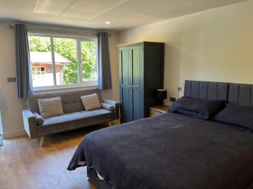 a bedroom with a bed and a chair and a window at Green haven in Winford