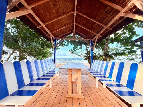 a table and blue and white chairs on a deck at Fresh Beach Resort in Cateel