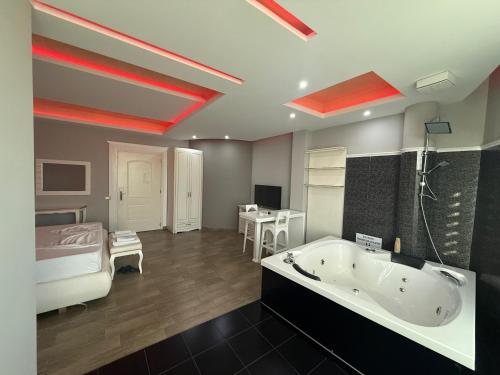 ein großes Badezimmer mit Badewanne und Bett in der Unterkunft Hotel Kresko in Lushnjë