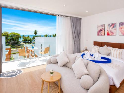 a living room with a bed and a large window at The Samui Villa Retreat in Ban Bang Po