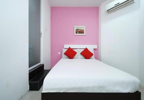 a bedroom with a white bed with red pillows at Cahaya Midah Hotel (BilikXpert) in Kuala Lumpur