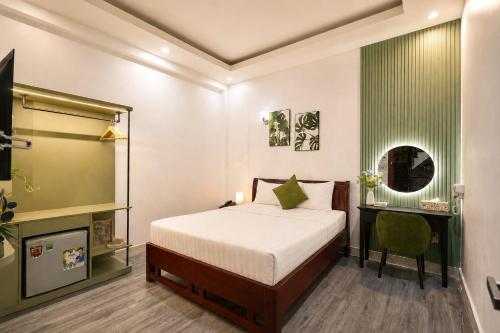 a bedroom with a bed and a desk and a mirror at Cactusland Hotel Tan Binh Near T3 Station in Ho Chi Minh City