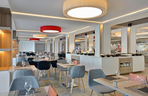 a restaurant with tables and chairs and a bar at SOL by Meliá Torremolinos Don Marco - Adults Recommended in Torremolinos