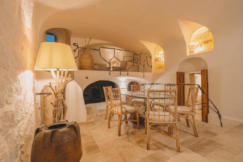 a dining room with a table and a fireplace at Hotiday Elite Olea Sanctuary in Olbia