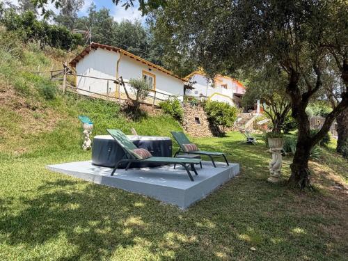 a bench sitting on a concrete slab in a yard at Magnolias Cottage with Jacuzzi and mountain view in Lousã