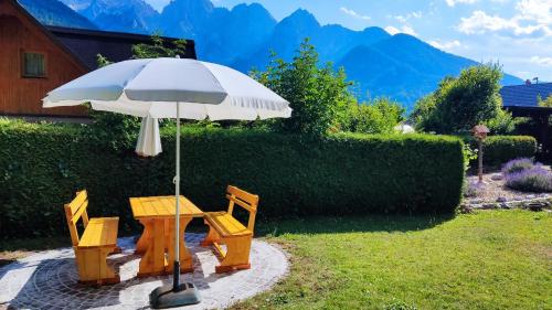 a table and two chairs under an umbrella at Hiša nasproti sonca in Kranjska Gora