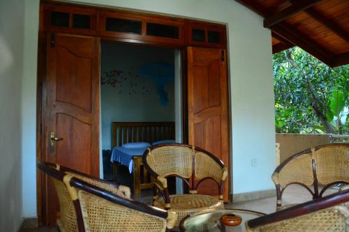 um quarto com cadeiras, uma mesa e uma porta em Binara Home Stay em Pollonaruva