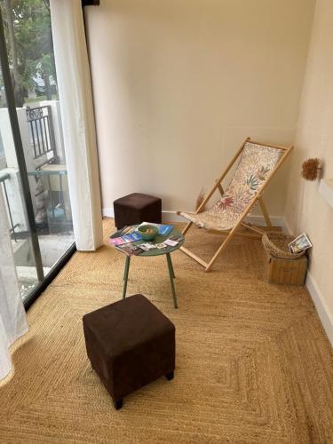 a living room with a chair and a table and a swing at Maison Teiss in Aigues-Mortes
