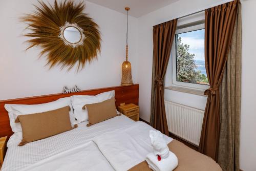a bedroom with a bed with a mirror and a window at Villa Nada in Lovran