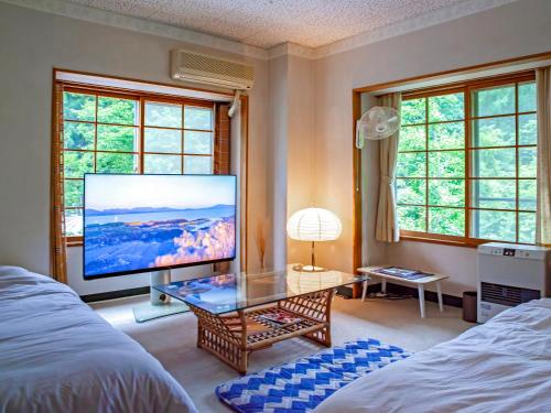 a living room with a large television and a table at 横磐梯リロード in Inawashiro