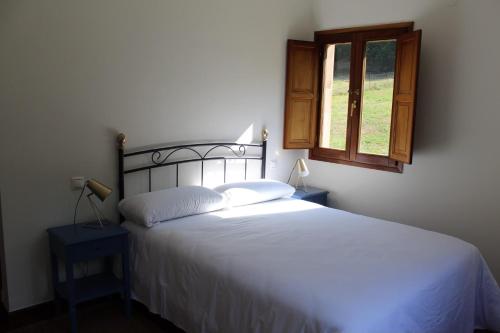 a bedroom with a white bed and a window at Los Jazmines de la Vega in La Vega