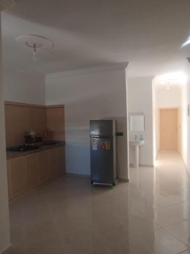 a kitchen with a refrigerator in the middle of a room at Résidence Maya 1 près de la plage in Ras El Ma