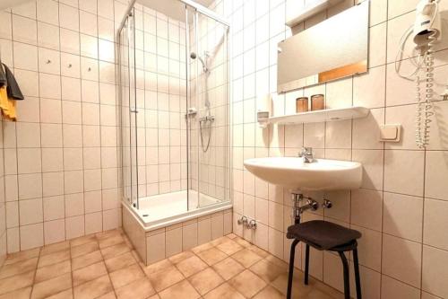 a white bathroom with a sink and a shower at Hotel und Restaurant Römerstein in Bad Aussee