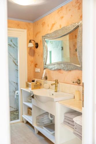 a bathroom with a sink and a mirror at “Athenas” Neoclassic Harbour View Apartment in Symi