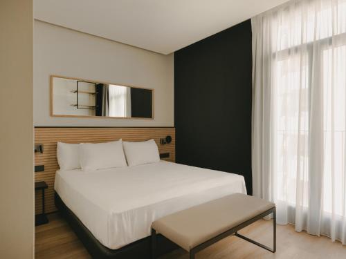 a bedroom with a large white bed and a window at Sercotel Valencia Ruzafa in Valencia