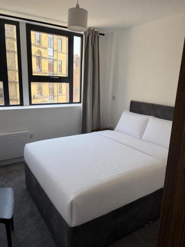 a white bed in a room with a window at 505 Broadway residence in Bradford