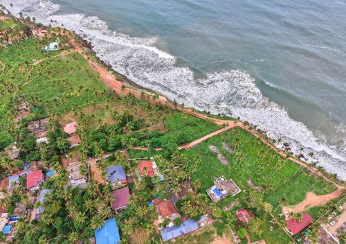 an aerial view of a house next to the ocean at Ocean View Beach Villa Varkala by VOYE HOMES in Varkala