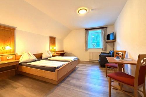a hotel room with a bed and a chair at Hotel und Restaurant Römerstein in Bad Aussee