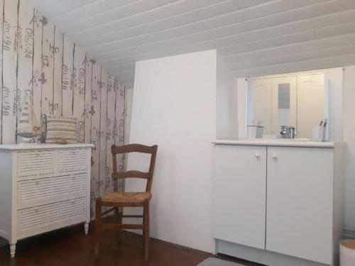 a kitchen with a chair and a cabinet and a sink at La charmante Capbretonnaise in Capbreton